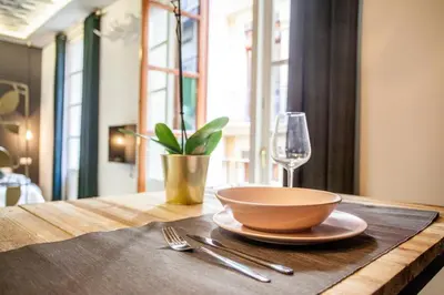 a wooden table with a bowl and a glass of wine at Mediterranean Flats Plaza Redonda in Valencia