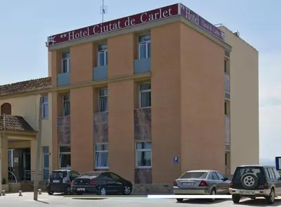 a building with cars parked in front of it at Hotel Ciutat de Carlet in Carlet