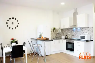 a kitchen with a table and a clock on the wall at Calle Cuenca in Valencia