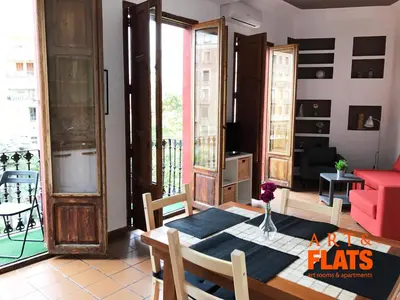 a living room with a table and chairs and a room with windows at CALLE CUENCA 2 in Valencia