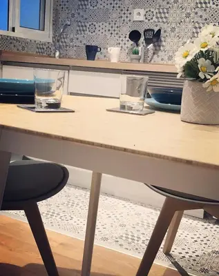 a table with two glasses and a vase of flowers at Casa Maritim Cabanyal in Valencia