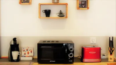 a microwave sitting on a counter next to a red toaster at Casa Maritim Cabanyal in Valencia