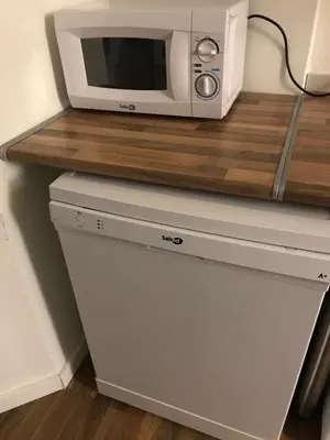 a microwave oven sitting on top of a refrigerator at Gran Apartamento, un lujo en playa El Saler - Valencia in El Saler