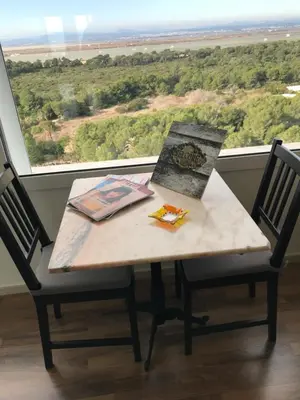 a table and chairs in front of a large window at Gran Apartamento, un lujo en playa El Saler - Valencia in El Saler