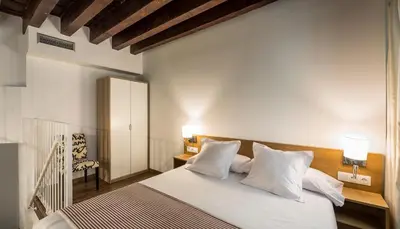 a bedroom with a large bed with white pillows at Catalina Suites San Nicolas in Valencia