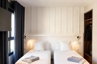 two beds in a room with a window at Ramirez Flats Valencia in Valencia