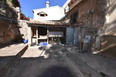 an alley with a building and a church at La Muralla Del Castillo in Chulilla