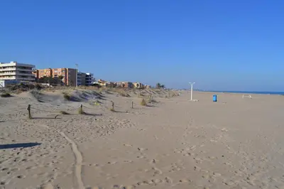 a sandy beach with buildings in the background at Apartamento Nuevo con Gran Terraza y Wifi en Canet in Canet de Berenguer