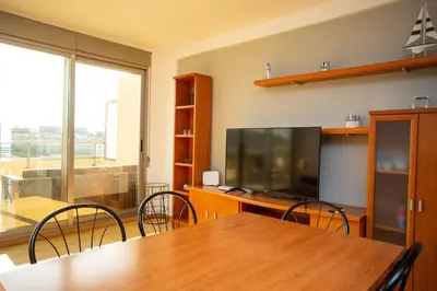 a dining room with a table and a flat screen tv at Cap Blanc Penthouse in Cullera