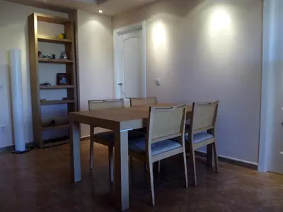 a dining room with a wooden table and chairs at Apartmento playa Almarda. Piscina&Parking in Almarda