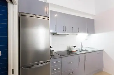 a kitchen with a stainless steel refrigerator and white cabinets at Valentia Apartments - Mercado Central in Valencia