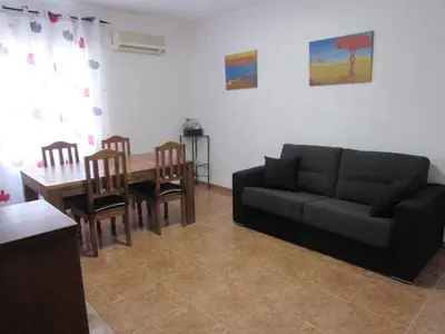 a living room with a couch and a table with chairs at Apartamento Playa Malvarrosa, Valencia in Valencia
