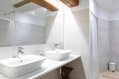 a white bathroom with two sinks and a mirror at ApartUP L' Almoina in Valencia
