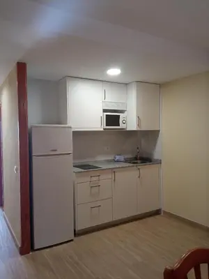 a kitchen with white cabinets and a white refrigerator at Apartamentos Satse Moncofa in Moncófar