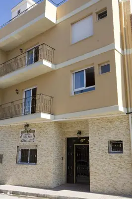 a large building with a black door and balcony at Hostal Casa Paco in Chilches