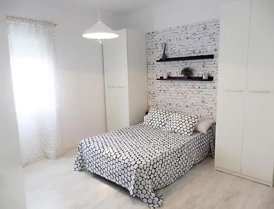 a bedroom with a bed and a brick wall at Campanar Flat in Valencia