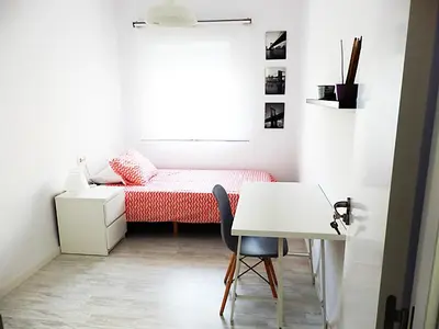 a small bedroom with a bed and a desk at Campanar Flat in Valencia