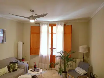 a living room with a couch and a ceiling fan at Apartamento céntrico Torres de Quart. in Valencia