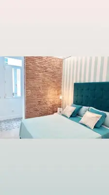 a bedroom with a large bed with a blue headboard at Apartamento Frederick “Centrico y con Clase” in Valencia