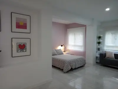 a white bedroom with a bed and a couch at Loft Office in Valencia