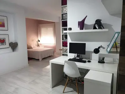 a white desk with a computer and a chair in a room at Loft Office in Valencia