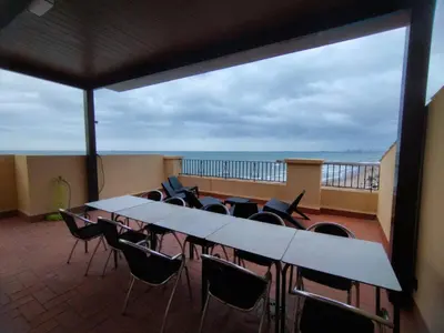 a balcony with a table and chairs and the ocean at ValenciaBeachHome in Port Saplaya