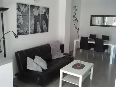 a living room with a black couch and a table at Carrer de Dénia in Valencia