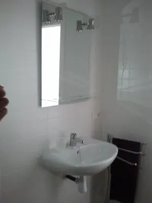 a white bathroom with a sink and a mirror at Carrer de Dénia in Valencia