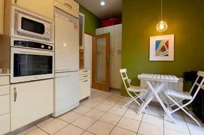 a kitchen with white appliances and a table with chairs at Junto al Mercado de Ruzafa in Valencia
