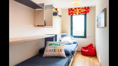 a small room with a blue couch and a desk at Apartamento en la Ciudad de las Ciencias y cerca de la playa in Valencia