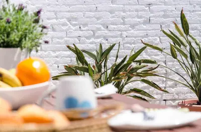 a table with a bowl of fruit and a cup of coffee at Cool Loft Malvarrosa Beach in Valencia