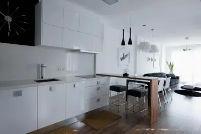 a kitchen with white cabinets and a table and chairs at Cool Loft Malvarrosa Beach in Valencia