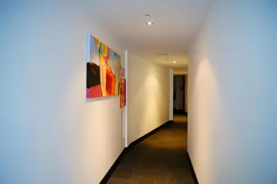 a hallway with two paintings on the wall at Hotel Sercotel Plana Parc in Alquerías del Niño Perdido