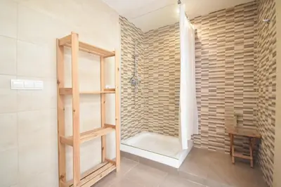 a shower with a glass door in a bathroom at Apartamento en casa historica en la playa in Valencia