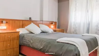 a bedroom with a large bed with a wooden headboard at AA la Nueva Fe in Valencia