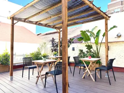 a wooden pergola with tables and chairs on a deck at Bird House in Valencia