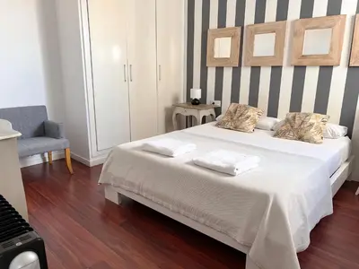a bedroom with a large white bed with a striped wall at Valencia Luxury - Boutique Market in Valencia