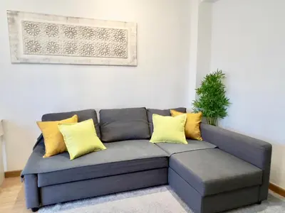a gray couch with yellow pillows in a living room at Cozy apartment in Valencia! WI-FI ! in Valencia