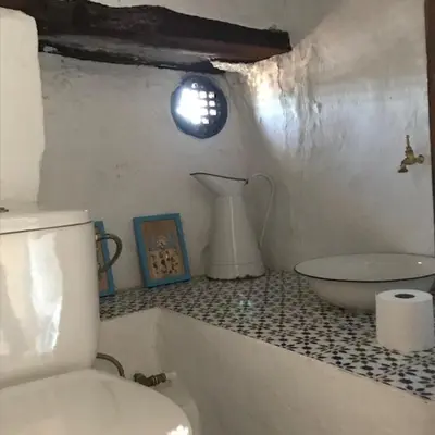 a bathroom with a toilet and a sink on a counter at Casa Rural La Antigua in Chelva