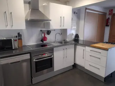a kitchen with white cabinets and stainless steel appliances at Casa rural La Senyora in Veo