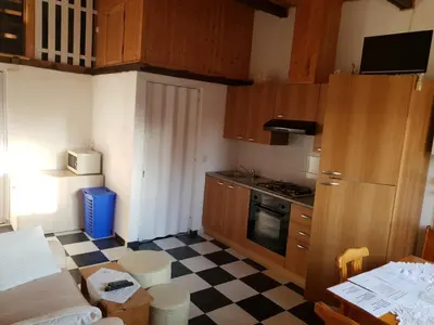 a small kitchen with wooden cabinets and a checkered floor at Casa Robion in Godelleta