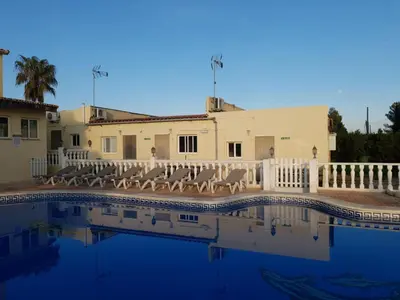 a house with a swimming pool with chairs and a building at Casa Robion in Godelleta