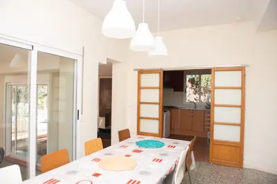 a dining room with a table and a kitchen at Villa Rive Rouge in Riba-Roja De Turia