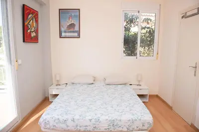 a white bedroom with a bed and two windows at Villa Rive Rouge in Riba-Roja De Turia