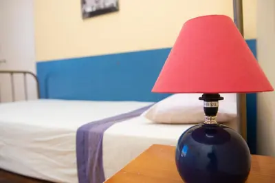 a red lamp sitting on a table next to a bed at Villa Rive Rouge in Riba-Roja De Turia