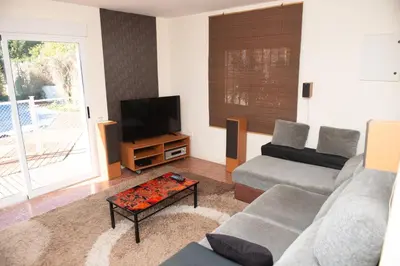 a living room with a couch and a flat screen tv at Villa Rive Rouge in Riba-Roja De Turia