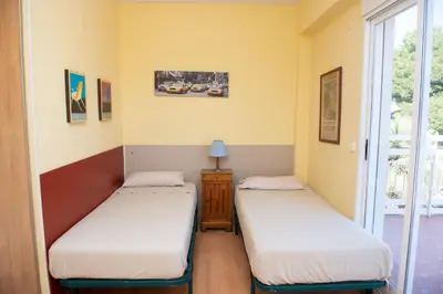 two twin beds in a room with a window at Villa Rive Rouge in Riba-Roja De Turia
