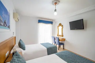 a hotel room with two beds and a desk and a television at Hostal RR Feria by Beleret in Valencia