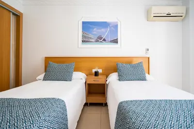 two beds in a hotel room with a view of the sydney opera house at Hostal RR Feria by Beleret in Valencia