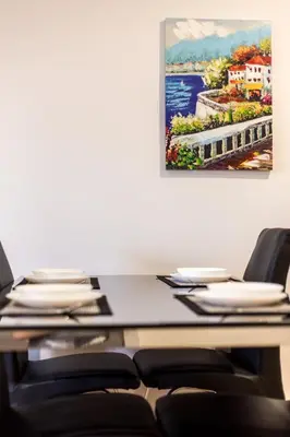 a table with chairs and a painting on the wall at Apartment on the beach,pool,WiFi,garage,Valencia in Valencia